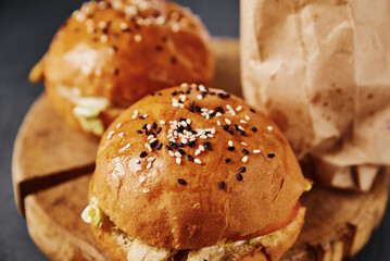 Two burgers and french fries on table on dark background, top view