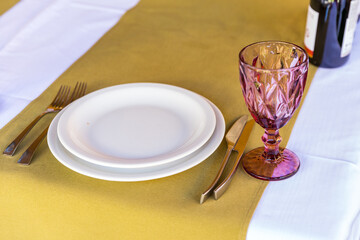 
Banquet table setting with white plates, glass glasses.