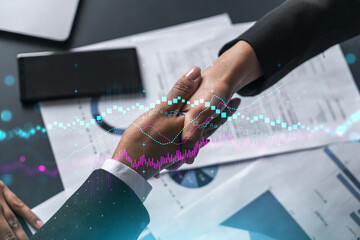 Multiexposure of two businesspeople handshake and forex graph hologram drawing background. Concept of financial market. Formal wear.