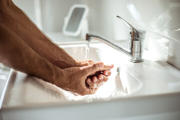 Close up photo of males hands with soap in the wash basin. Safety health procedure, pandemic,...