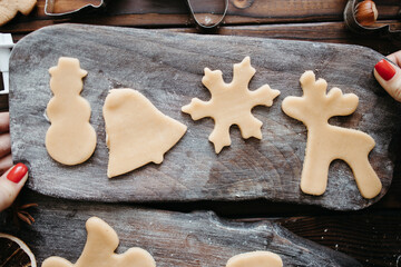 Christmas and New Year celebration traditions. Family home bakery, cooking traditional festive sweets. Gingerbread dough with christmas theme raw cookies, flat lay