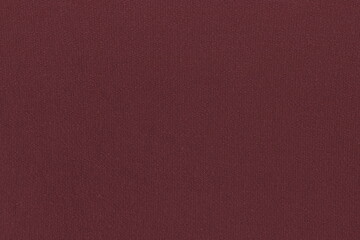 The texture of a simple knitted cotton fabric on the wrong side with a clear interweaving of maroon...
