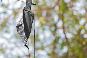 The picture of cloth mask hanging after washing outside to dry by sunlight before reuse course. The reason is to save money during The Coronavirus disease (COVID 19) effect.