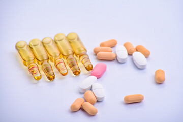 many medical ampoules in a row and pills on a white background.Concept of vaccine or pills. Close-up