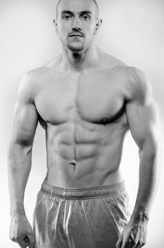 Sporty guy posing in the Studio on the background. Sports, beauty, black and white photography