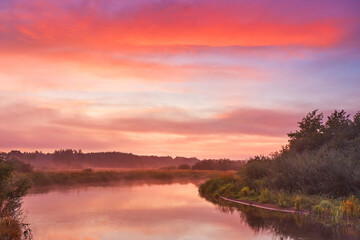 Fog over lake, Colorful dawn. Cloudy sunrise. Dusk fall colors.