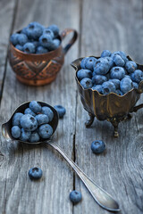 Blueberry berries on an old wooden background, vintage style photo.