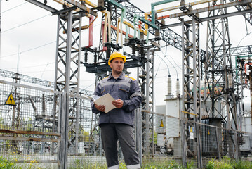 Fototapeta premium The energy engineer inspects the equipment of the substation. Power engineering. Industry