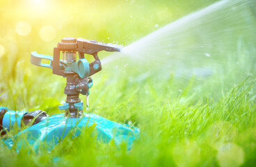 Sprinkler head watering green grass lawn. Gardening concept. Smart garden activated with full...