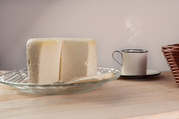Minas cheese and coffee cup arranged on a table with beige tablecloth and gray fudo, selective focus.