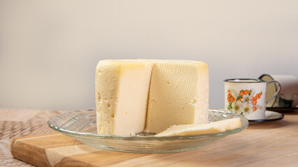 Minas cheese and coffee cup arranged on a table with beige tablecloth and gray fudo, selective focus.