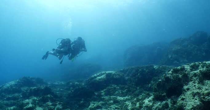 beginner scuba divers learning to dive in blue water underwater scenery of a lady and teacher