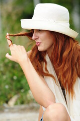 Elegant smoking woman. Portrait of a red-haired girl with a cigar