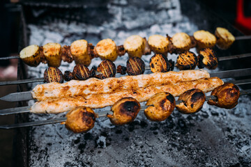 the meat on the coals and skewers of barbequed meats are cooked on skewers in the grill