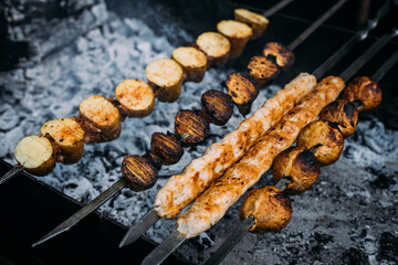 the meat on the coals and skewers of barbequed meats are cooked on skewers in the grill