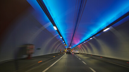 
fast-moving cars and highway inside the traffic tunnel