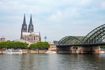 Cologne Cathedral and Hohenzollern Bridge over Rhine river on cloudy days