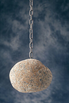 Large stone boulder suspended from a chain