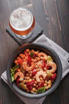 Shrimp with chickpea stew and beer on table, top view