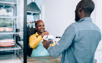 Joyful ethnic woman giving order client in cafe