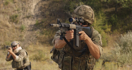 Fototapeta premium Male soldier reloading firearm during war