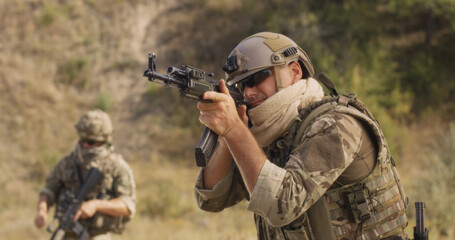 Fototapeta premium Military man reloading and aiming rifle