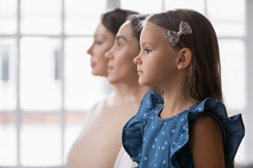 Profile side view of beautiful three female generations looking at distance. Head shot of little adorable girl with beautiful young mother and elderly granny, relatives heredity unity concept. - Powered by Adobe