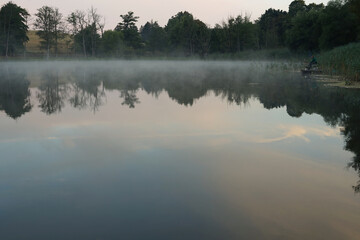 Obraz na płótnie Canvas fog on a lake surrounded by trees