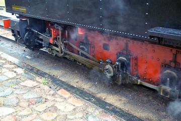 Part of active steam locomotive. Narrow-gauge railway in an amusement park.