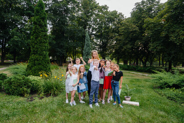 Obraz premium A teacher teaches a class of children in an outdoor Park. Back to school, learning during the pandemic