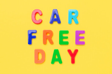 Multicolored text Car Free Day on yellow background. Concept of international car free day on September 22. Top view
