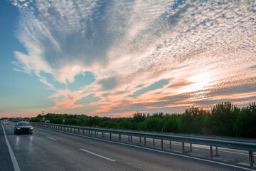 Roadside at sunset with fragmented clouds in the background