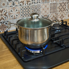 Cooking on a gas stove. The pot on gas burner.