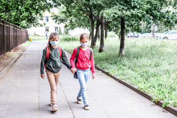 Two girls wearing protective face mask and going back to school during coronavirus pandemic.