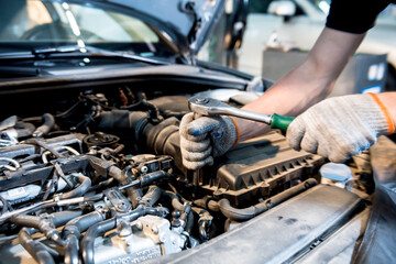 Car mechanic repair engine at service station. Car repair