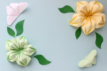 Origami paper background with butterflies, flowers and leaves. Origami composition. Paper craft