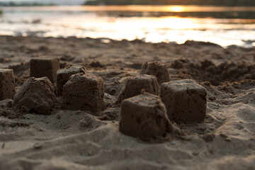 sand cakes on the beach by the river at sunset, close-up