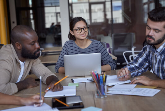 Having A Meeting. Three Young Multicultural Business People Working Together In The Modern Office, Discussing Project Or Sharing Ideas