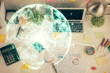 Business theme hologram drawings over computer on the desktop background. Top view. Multi exposure....