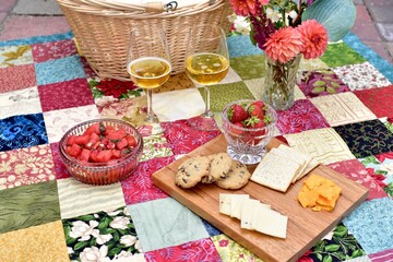 Outdoor summer gourmet picnic basket foods in beautiful romantic garden setting for special staycation relaxing meal on warm evening to share with someone special