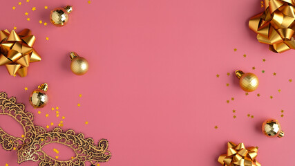 Golden Christmas party decorations, balls, confetti stars, carnival mask on pastel pink background. Christmas party or masquerade concept. Flat lay, top view.