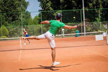 Young athletic couple playing tennis on the court.