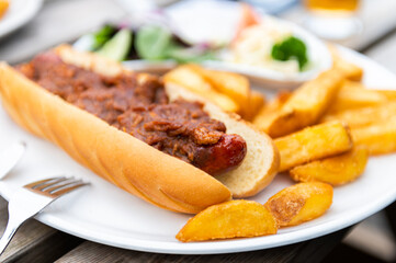 Food on the English Pub such as hot dog with beefy sauce, chips and salad