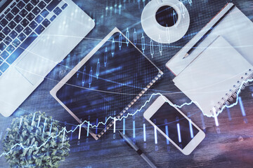 Double exposure of forex chart hologram over desktop with phone. Top view. Mobile trade platform concept.