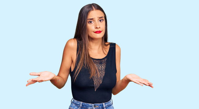 Young hispanic woman wearing casual clothes clueless and confused with open arms, no idea concept.