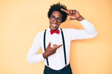 Handsome african american man with afro hair wearing hipster elegant look smiling making frame with hands and fingers with happy face. creativity and photography concept.