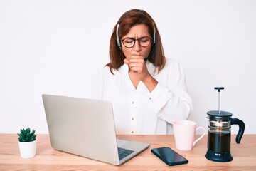 Middle age brunette hispanic woman working at the office wearing operator headset feeling unwell and coughing as symptom for cold or bronchitis. health care concept. - obrazy, fototapety, plakaty