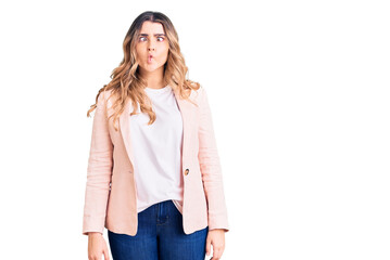 Young caucasian woman wearing business clothes making fish face with lips, crazy and comical gesture. funny expression.