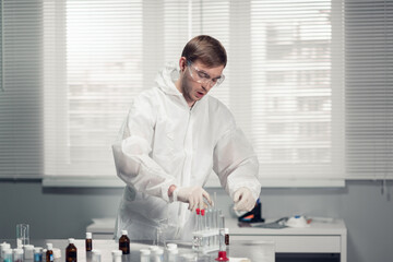 Laboratory assistant putting test tubes into the holder.