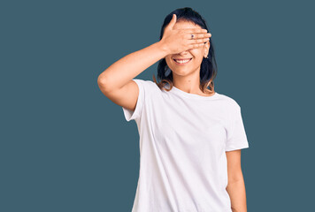 Young woman wearing casual clothes smiling and laughing with hand on face covering eyes for surprise. blind concept.